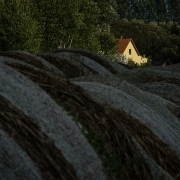 Heuballen mit beleuchtetem Haus im Hintergrund, Fotografie von Klaus Wißkirchen