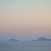 Im Dunst der Morgen- oder Abendröte sind zwei dunkle Inseln.