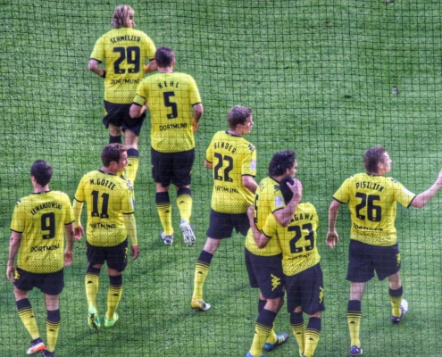 Auf dem Foto im Querformat sind 8 Spieler von Borussia Dortmund im gelben Trikot zu sehen