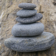 Das querformatige Foto zeigt ein Steinmännchen von 5 grauen Steinen.