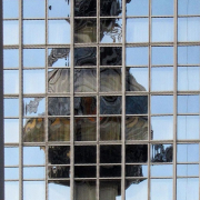 Auf dem hochformatigen Foto sieht man das verzerrteSpiegelbild des Fernsehturms in einer Scheibe.