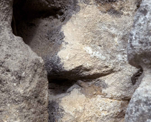 Das hochformatige Foto zeigt einen Ausschnitt von zwei Felsen, die ein Gesicht bilden.