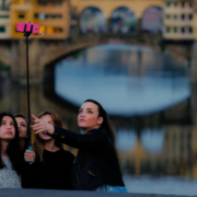Auf dem querformatigen Foto fotografieren sich 4 junge Frauen mit Hilfe einer Handystange.