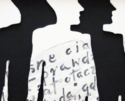 Das querformatige Bild zeigt den scherenschnittigen Umriss von Menschen mit einem in polnischer Sprache handgeschriebenen Zettel.