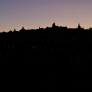 Das querformatige Foto zeigt die Silhouette einer Stadt im Abendlicht.