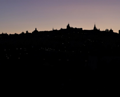 Das querformatige Foto zeigt die Silhouette einer Stadt im Abendlicht.