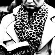 Auf dem hochformatigen Schwarzweißfoto liest eine Frau mit heruntergezogenen Mundwinkeln in dem Buch mit dem Titel Dracula.