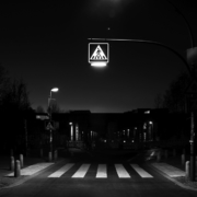 Das querformatige Foto zeigt die Straßenbeleuchtung über einem Zebrastreifen.